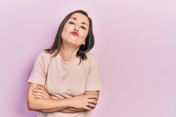 Fototapeta premium Middle age hispanic woman with arms crossed gesture looking at the camera blowing a kiss being lovely and sexy. love expression.