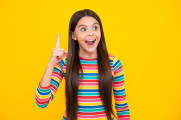 Excited teenager girl. Confident and successful young teenager child over isolated yellow background showing and pointing up with finger number one. Kid have an good idea.
