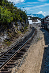 Fototapeta premium A view down the tracks at the highest point of the White Pass and Yukon railway near Skagway, Alaska in summertime