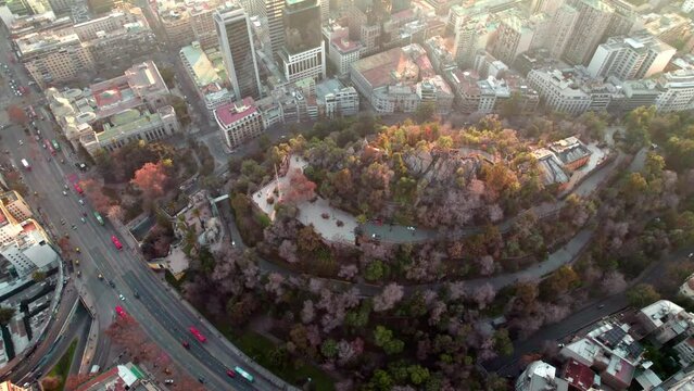 Aerial orbit of Santa Lucia Hill with autumnal trees, Caupolican Terrace, between Alameda avenue and Santiago buildings, Chile