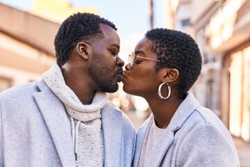Man and woman couple standing together kissing at street