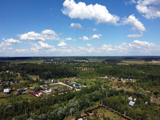 Fototapeta na wymiar Countryside landscape with many private houses with homesteads in the the middle band of Russia in the bright sunny summer day aerial view