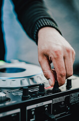 DJ Hands creating and regulating music on dj console mixer in concert outdoor