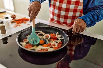 Senior man cooking at kitchen