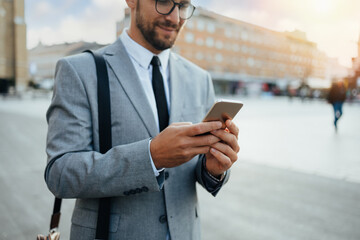 Close up shot of businessman's hand holding smart phone. Communication technology concept. Cinematic color grade.