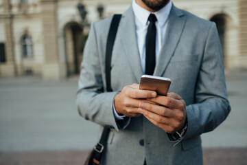 Close up shot of businessman's hand holding smart phone. Communication technology concept. Cinematic color grade.