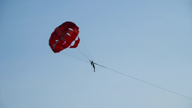 Parasailing is active type of recreation. Extreme entertainment for tourists. People flying on parachute wide. Parachute flying over water