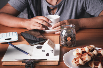 A woman picking up a coffee cup on her desk full of things.Hard work concept.