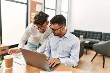 Two hispanic men business workers smiling confident working at office