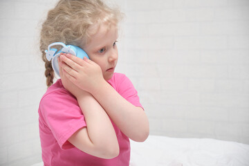 preschooler girl in a pink t-shirt hears the ticking of an alarm clock, children's healthy sleep concept
