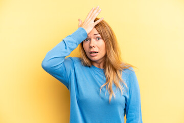blonde pretty woman raising palm to forehead thinking oops, after making a stupid mistake or...