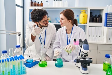 Man and woman scientist partners smiling confident working at laboratory