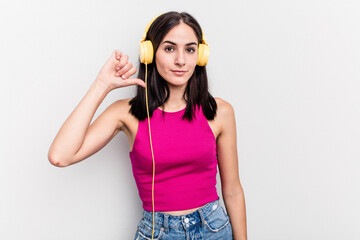 Young caucasian woman listening to music isolated on white background showing a dislike gesture, thumbs down. Disagreement concept.