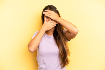 asian pretty woman covering face with both hands saying no to the camera! refusing pictures or...