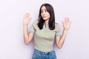 Young caucasian woman isolated on pink background being shocked due to an imminent danger