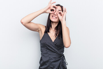Naklejka premium Young caucasian woman isolated on white background showing okay sign over eyes