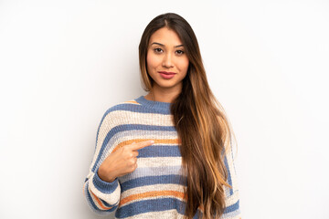 asian pretty woman looking proud, confident and happy, smiling and pointing to self or making...