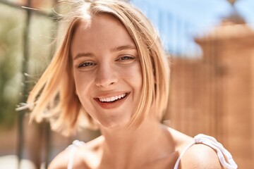 Young blonde woman smiling confident standing at street