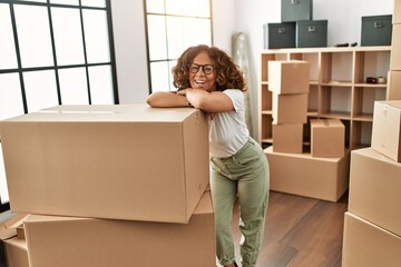 Middle age hispanic woman smiling confident wearing glasses at new home