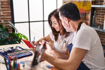 Middle age man and woman artists drawing on notebook using touchpad at art studio