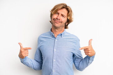 blond adult man looking proud, arrogant, happy, surprised and satisfied, pointing to self, feeling...