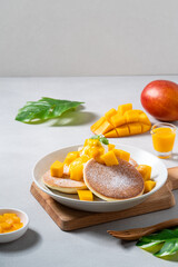 Delicious Japanese souffle pancake with dice mango and jam on white table background.