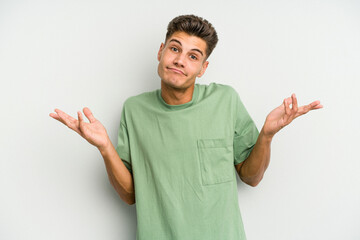 Young caucasian man isolated on white background doubting and shrugging shoulders in questioning...
