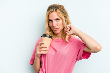 Young caucasian woman holding a take away coffee isolated on blue background showing a dislike gesture, thumbs down. Disagreement concept.