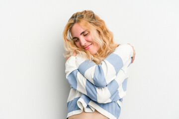 Young caucasian woman isolated on white background hugs, smiling carefree and happy.