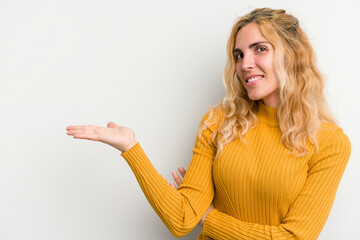 Young caucasian woman isolated on white background showing a copy space on a palm and holding...