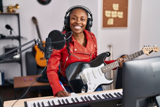 African american woman musician composing song at music studio