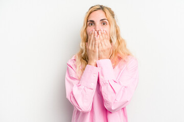 Young caucasian woman isolated on white background shocked covering mouth with hands.