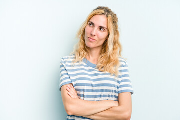 Young caucasian woman isolated on blue background dreaming of achieving goals and purposes