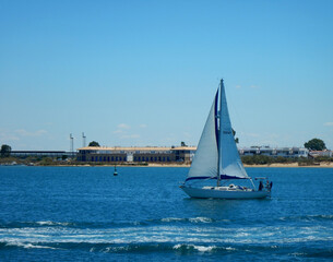 Small white sailing ship near the shore