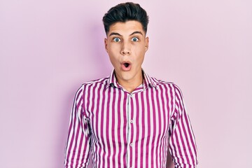 Fototapeta premium Young hispanic man wearing casual clothes afraid and shocked with surprise and amazed expression, fear and excited face.
