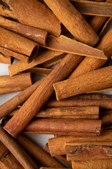 Food spice background with cinnamon sticks on light surface top view