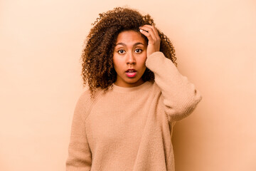 Young African American woman isolated on beige background being shocked, she has remembered important meeting.