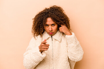 Young African American woman isolated on beige background pointing temple with finger, thinking, focused on a task.