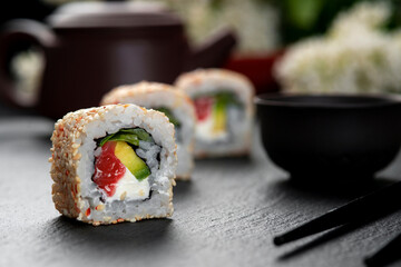 Roll with fish sushi with chopsticks. Philadelphia Roll . Japanese kitchen, restaurant.