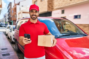 Young hispanic man courier using smartphone holding package at street