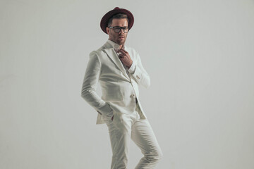 handsome businessman in white suit opening shirt collar