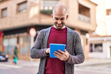 Young man smiling confident using touchpad at street