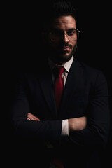 portrait of attractive young businessman in suit folding arms