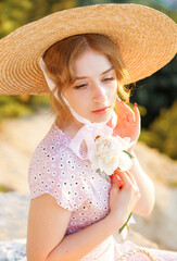 Beautiful girl in straw hat on the mountain at sunset. Vintage tone.