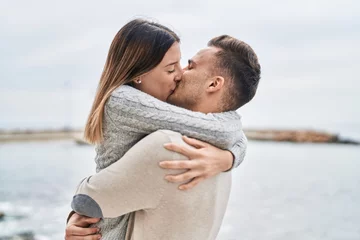 Fotobehang Man en vrouw paar knuffelen elkaar zoenen aan zee © Krakenimages.com