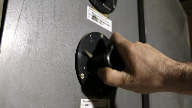 A slow motion video of a man's hand turning an old remote control key on a plant