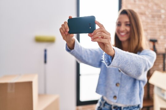 Young woman making selfie by the smartphone standing at new home
