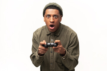 Excited young multiracial man playing video games and looking at camera with surprised face,...