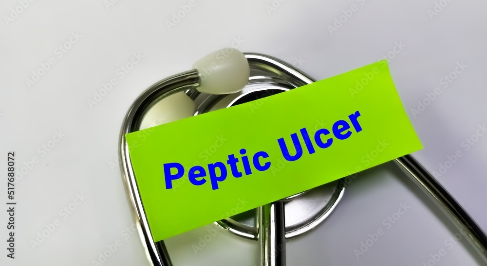 Sticker peptic ulcer medical term word in green card on white background with stethoscope. medical concept.