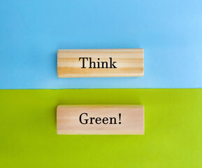 Think green text written on wooden cubes on blue and green background